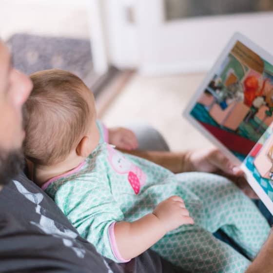 Man Holding Baby reading book